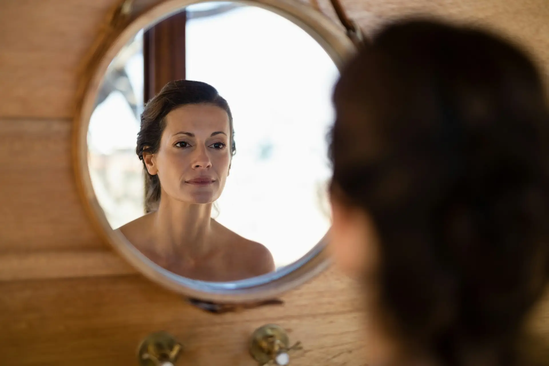 Woman looking at mirror in cottage